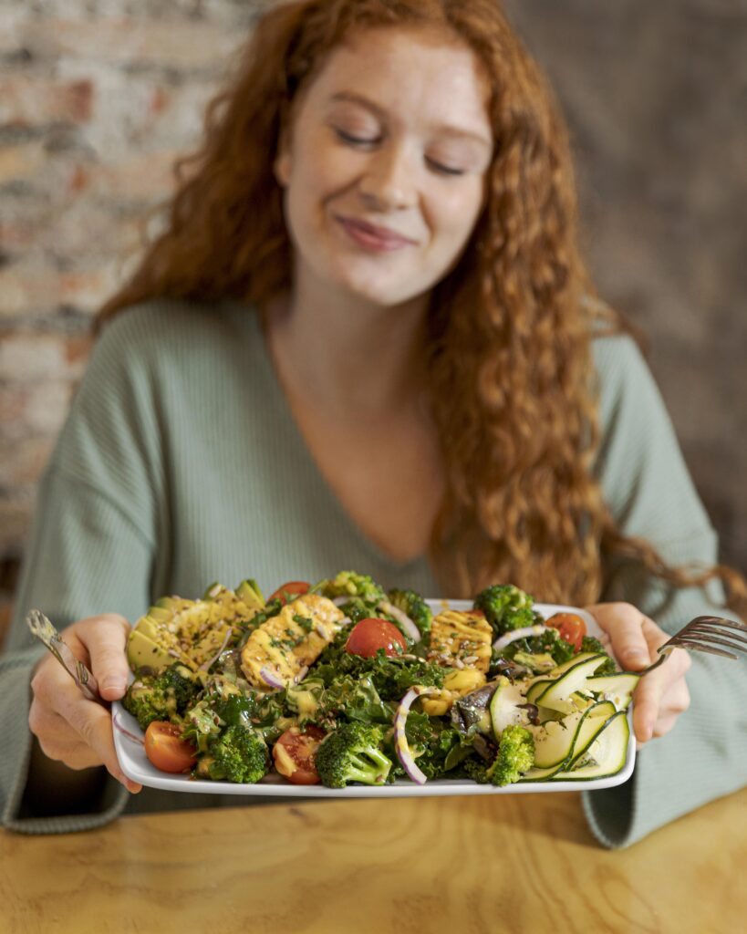 Natural photo of a table with hormone-friendly foods (salmon, leafy greens, berries, flaxseeds) in a bright, inviting kitchen setup.