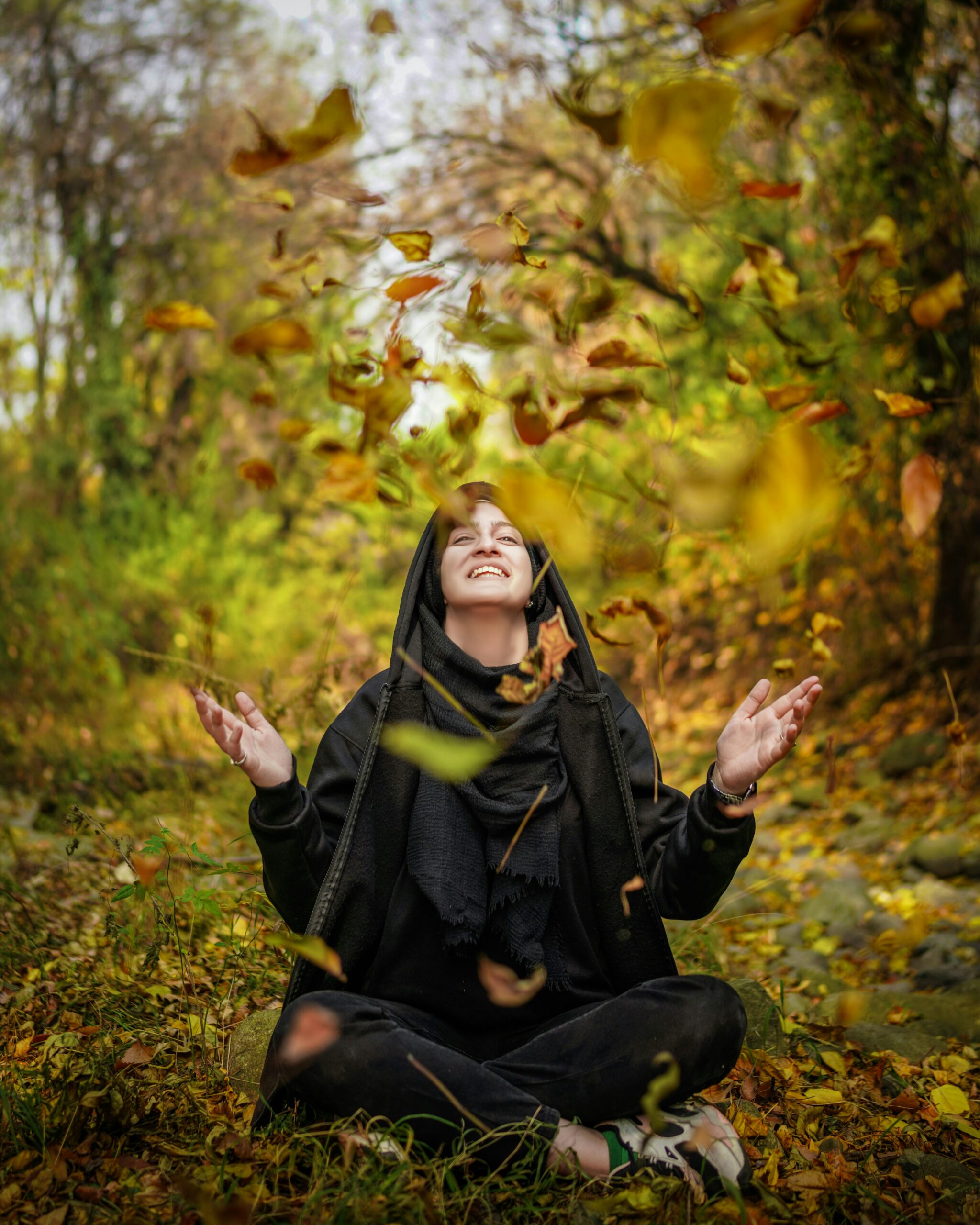 Woman in her 50s doing light stretches outdoors, smiling and relaxed.