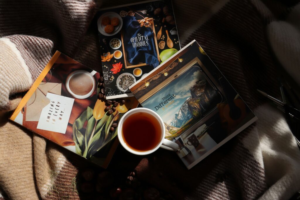 Natural photo of a notebook left open beside a pair of glasses and a cardigan on a chair — suggesting pause, routine interruption, and emotional processing.